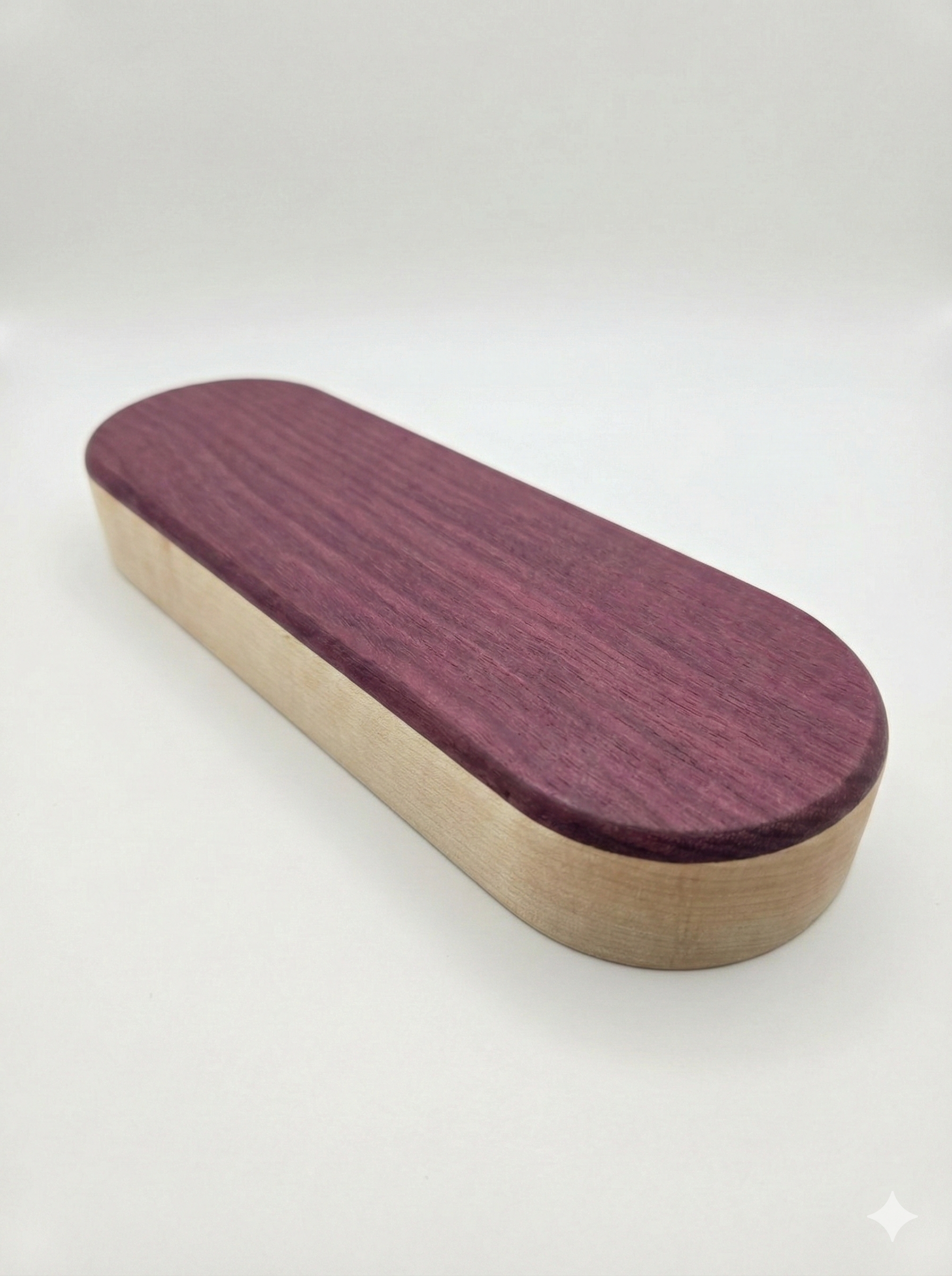 Oval shaped wooden object with purple wooden top and white wooden bottom